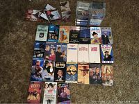 Overview of assorted VHS tapes laid out on carpet showing movie covers and titles.