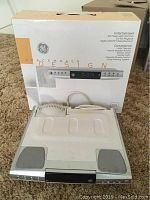 Photo of the GE Spacemaker Design Entertainment unit placed on carpet with original packaging box behind it.