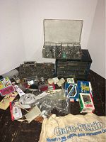 Overview photo of the assortment of hardware items including multiple storage organizers, boxes, and a cloth bag.
