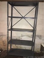 Front view of the entire black metal shelving unit showing all four shelves and cross-bracing at the back.
