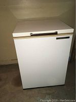 General Electric white deep freezer chest front view showing rectangular shape, flat top lid, and handle.