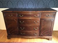 Front view of vintage wooden buffet server showing 6 drawers and 2 cabinets with brass handles.