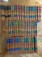 Photo showing all 38 volumes of The Great Ideas Encyclopedia collection 1963 arranged on floor, varied spine colors with gold embossed titles and volume numbers.