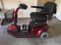 Right-side view of scooter showing platform, wheels, seat and attached charger.
