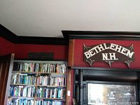 Vintage Bethlehem N.H. wooden sign mounted above a doorway, showing its overall shape and decorative style.