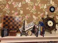 Checkerboard background with Springfield sign, Eiffel Tower statue, ships wheel clock, books, metal tissue holder, and wooden box.