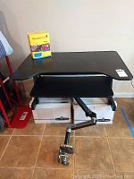 Front view of the adjustable height arm clamp desk with Rosetta Stone software on top, showing the clamp arm at bottom front.