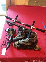 Photo showing Homedics massager, inline skates, and chin-up bar on red surface