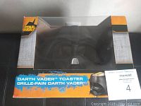 Front view of the Darth Vader toaster box with clear window showing the black helmet-shaped toaster inside.