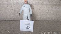 Full body view of the Arkham Dr. Strange plastic figure standing against a wall on carpet.