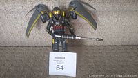 Full front view of the Arkham Firefly figure showing wings deployed and weapon held forward.