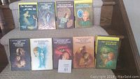 Front covers of ten vintage hardcover Nancy Drew books, showing colorful illustrated dust jackets and titles.