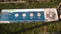 Photo of the original Kobalt overhead storage unit packaging showing product dimensions and features with some water damage on the box.