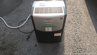 Front view of Frigidaire Premiere dehumidifier showing silver top panel with air vent and power plug on ground.