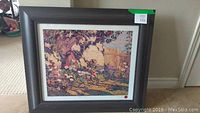 Full view of one framed print depicting a tree, garden and flowers in autumn tones, with label showing artist and painting title.