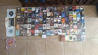 Overview of tapes and four 45 RPM vinyl records laid out on floor showing album covers and labels visible