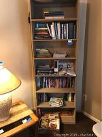 Books on a bookshelf arranged in multiple shelves with some stacked. Bookcase is not included.