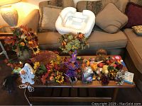 Fall-themed decorations including faux flower arrangements, plastic lighted ghost, and various styrofoam pumpkins and squash on coffee table.