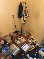 Full view of the corner with Patrol enteral pump on pole, Kangaroo Joey Pump with carrying case, boxes of wound gauzes, and medical supplies scattered on floor and shelves.