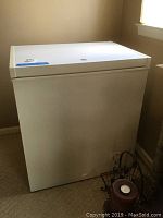White Kenmore chest freezer closed, showing overall condition and dimensions