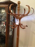 Wooden coat rack showing the curved hooks at the top