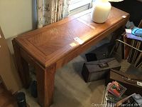 Full view of the wooden sofa table showing top surface and legs in a living room setting.