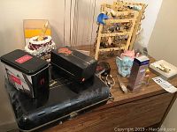 View of the nightstand with earring stands and various items including watch boxes and decorative pieces.