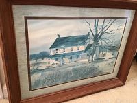 Framed painting of farmhouse landscape in muted blue and brown tones with wood frame