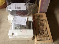 Three kitchen appliances boxed and wrapped: George Foreman toaster, Toastmaster pancake maker, and Sears Double Buffet Range box