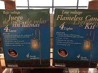 Two unopened boxes of Manor House flameless candle lighting kits, each box contains four copper lantern garden lights with shepherd hooks.