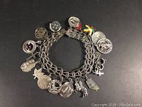 Full view of the charm bracelet showing all 20 silver charms attached and the overall look and length of the bracelet.