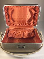 Open view showing tangerine satin interior with elastic pockets and decorative stitching.