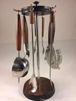 Front view of rotating bar tool stand holding six bar tools with wooden handles made of stainless steel.