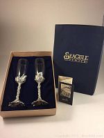 Two Seagull Pewter wine flutes displayed in original box with box lid showing brand logo and accompanying pamphlets.