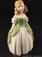 Front view of Royal Doulton Penny figurine showing detailed face and dress.