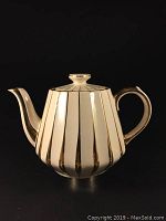 Front view of Sadler Art Deco teapot showing white ceramic body with gold vertical stripes, lid and handle with gold accents