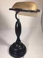 Photo showing side view of lamp with black base and alabaster style shade highlighting pull chain and shape.