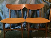 Front view of pair of solid teak chairs with upholstered seats showing condition and style