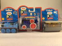 Three boxed wooden Thomas & Friends trains including Thomas, Fergus with red flywheel, and Percy