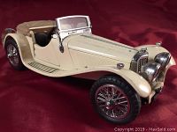 Front angle view of beige 1938 Jaguar SS100 precision diecast model showing body contours, chrome grille, headlights, and windshield.