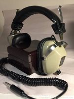 Vintage REALISTIC NOVA PRO Stereo Headphones displayed with coiled cable and 1/4 inch plug alongside wooden box