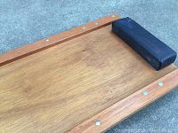 Top view close-up detail of the wooden creeper's surface and black cushioned headrest