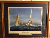 Framed print showing two twelve-meter yachts sailing with a lighthouse in the background.