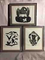 Three framed black and white Inuit art prints arranged in a group against a neutral backdrop.