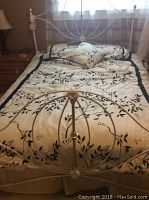 Full view of queen bed setup showing white metal frame with mattress and box spring
