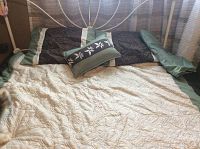Full view of queen size comforter set on metal headboard bed showing cream quilted comforter and pillow arrangement