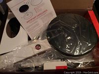 Unboxed Velata crepe maker unit wrapped in plastic inside original box, showing crepe plate and handle