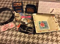Full view of lot items on carpet including springform pan, decorative bowl, wooden boxes, ceramic creamers, decorative palette, can opener