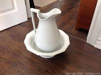 Photo of the white ceramic ewer placed inside the octagonal ceramic basin, both plain white and antique.