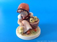 Front angled view of Hummel figurine 'The Chick Girl' showing girl with chicks and basket